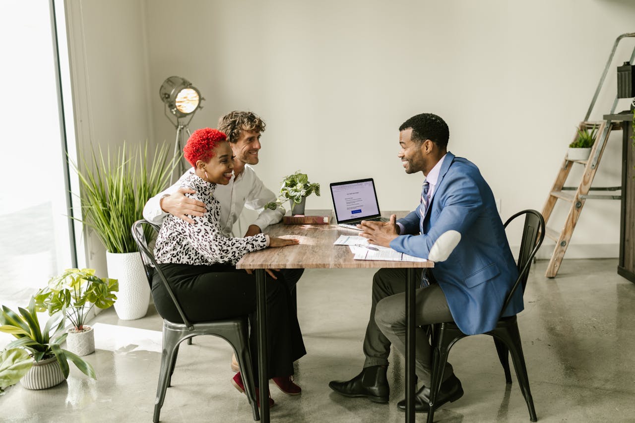 Three professionals in smart casual attire having a meeting in a modern office setting.