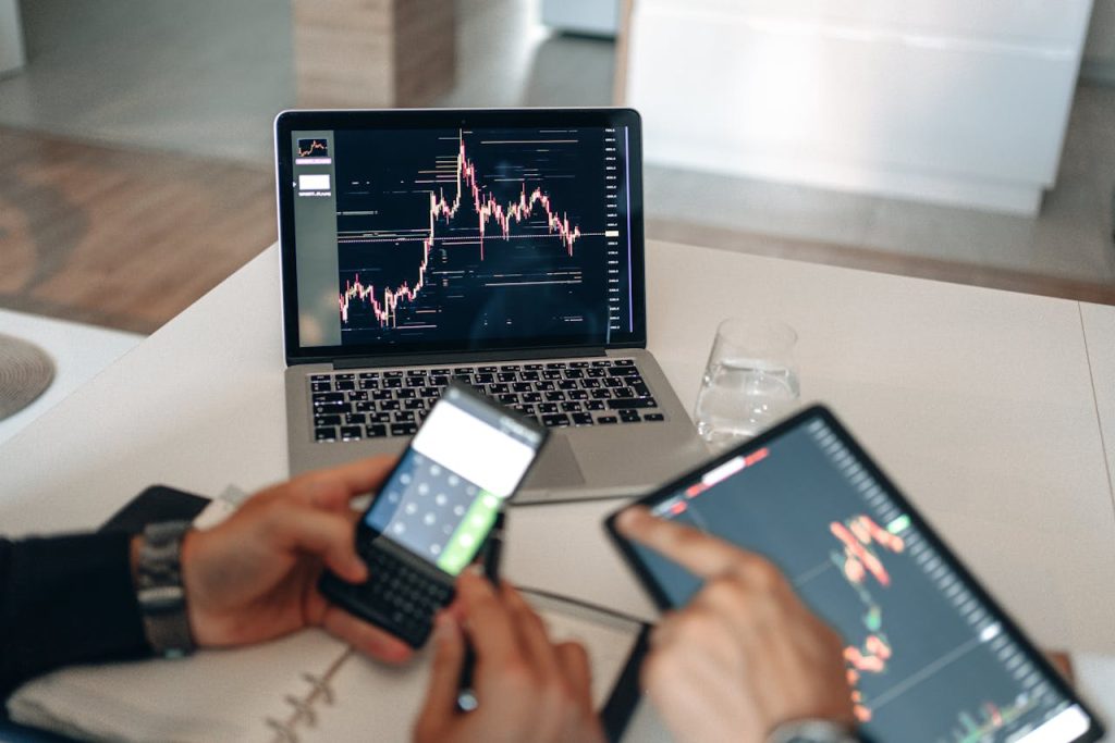 Demo Post 1 Hands using digital devices for financial analysis at a modern desk setup.