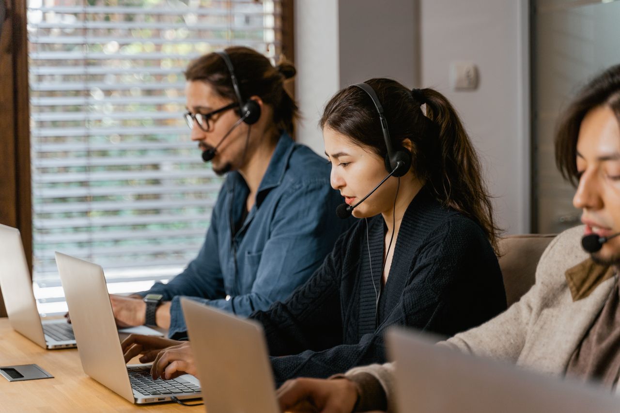 services-04 Team of professionals in a call center providing customer support using laptops and headsets.